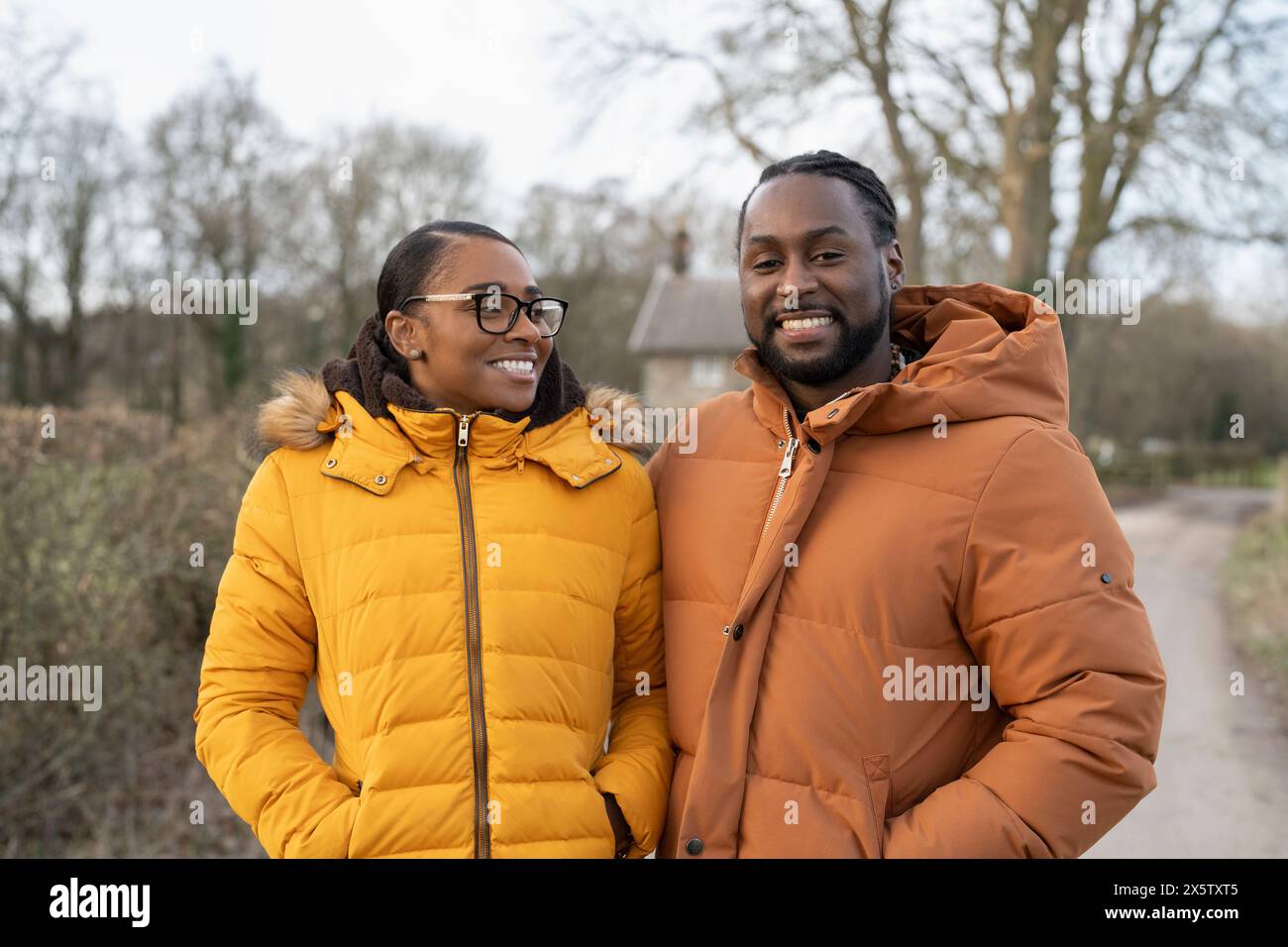 Couple en vestes d'hiver marchant dans un cadre rural Banque D'Images