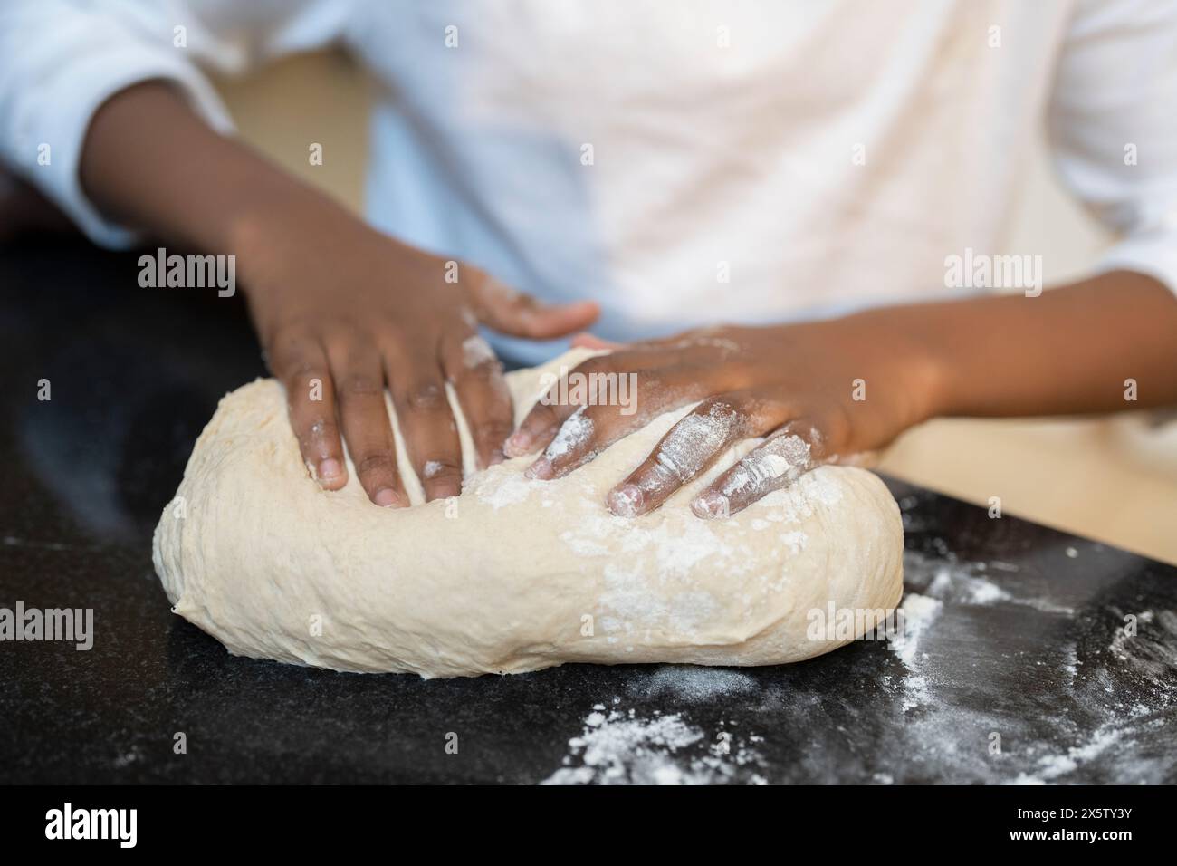 Garçon préparant la pâte sur le comptoir de cuisine Banque D'Images