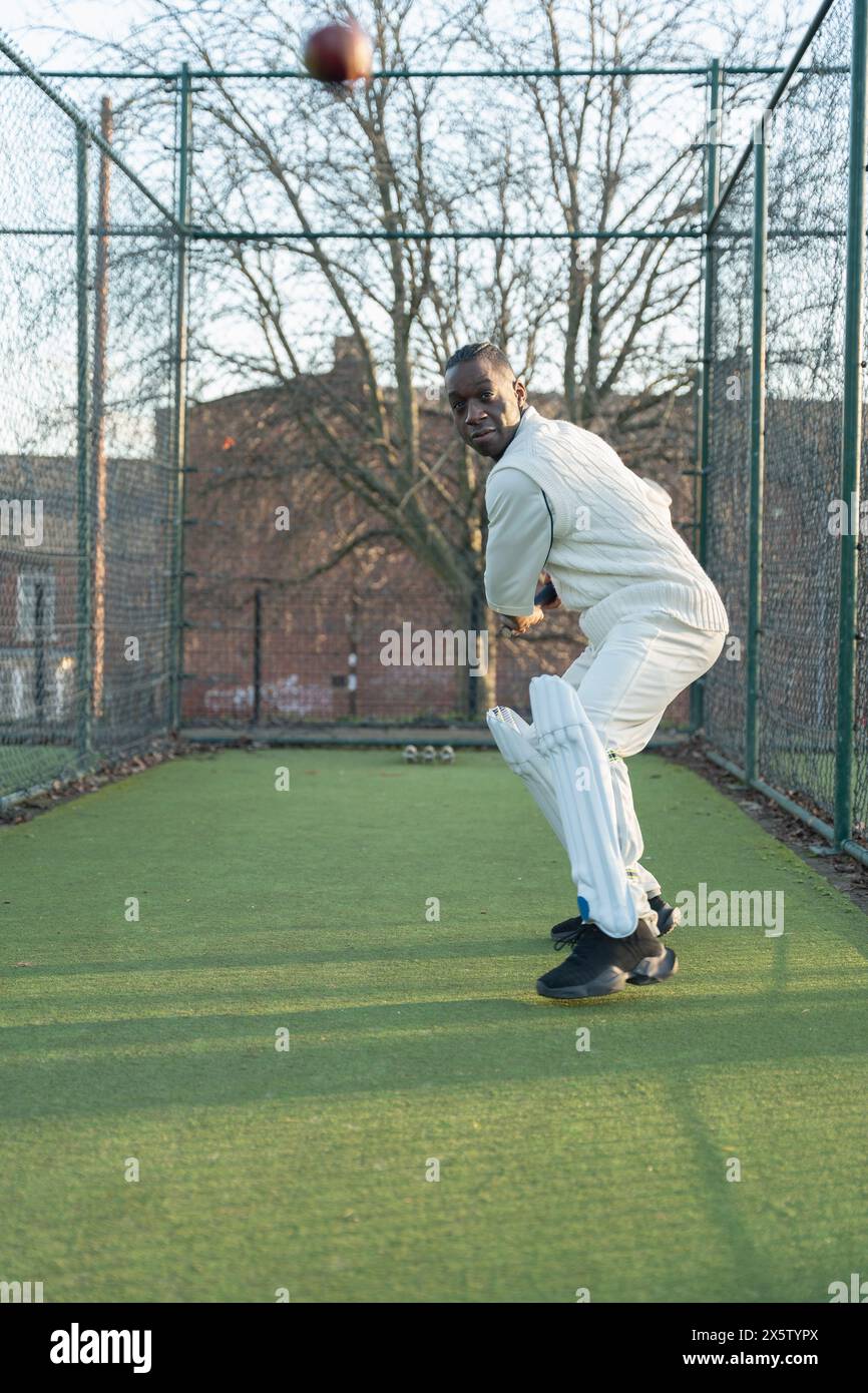 Homme jouant au cricket sur un terrain de sport extérieur Banque D'Images