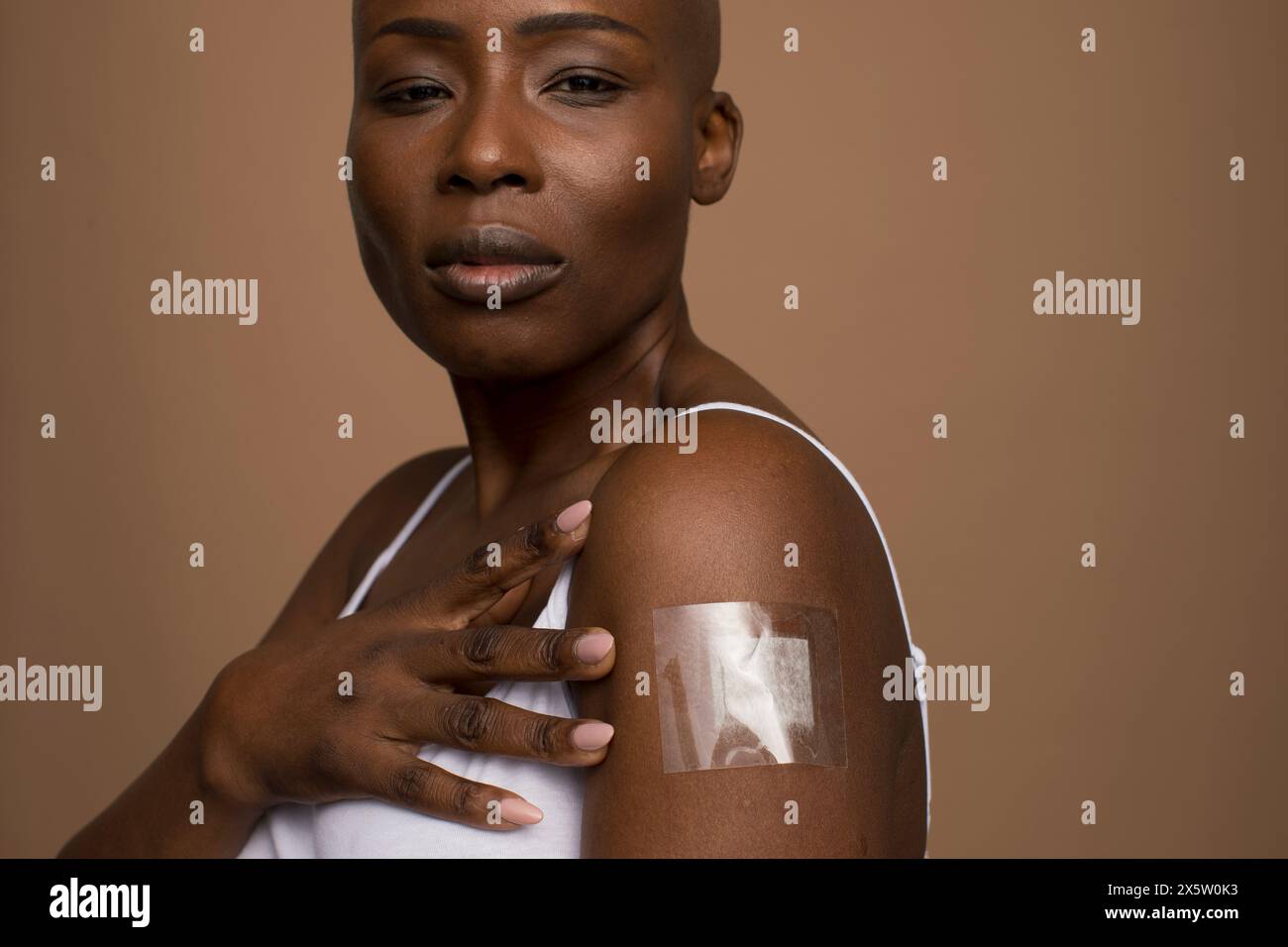 Portrait studio de femme avec bandage adhésif sur le bras Banque D'Images