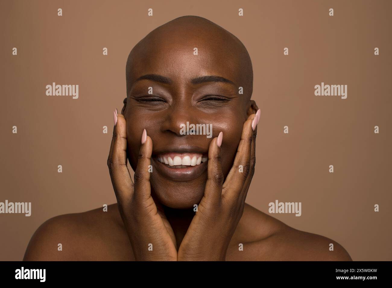 Portrait studio de femme souriante avec la tête rasée Banque D'Images