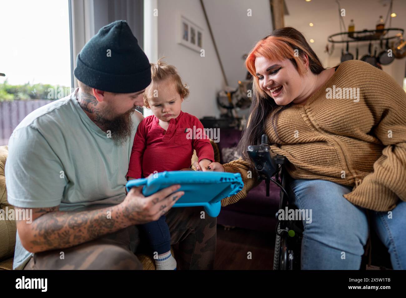 Femme en fauteuil roulant jouant avec la famille à la maison Banque D'Images