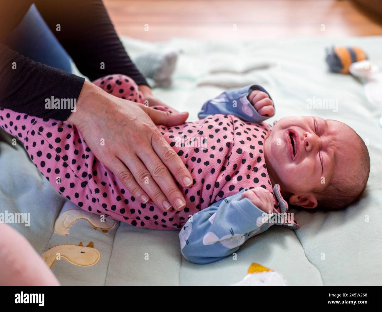 Mère frottant le ventre de sa fille en bas âge (0-1 mois) Banque D'Images