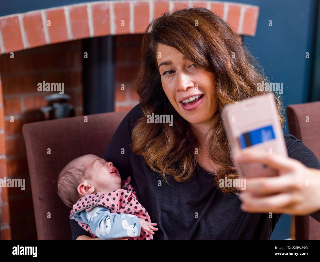 Femme avec bébé fils (0-1 mois) prenant selfie à la maison Banque D'Images