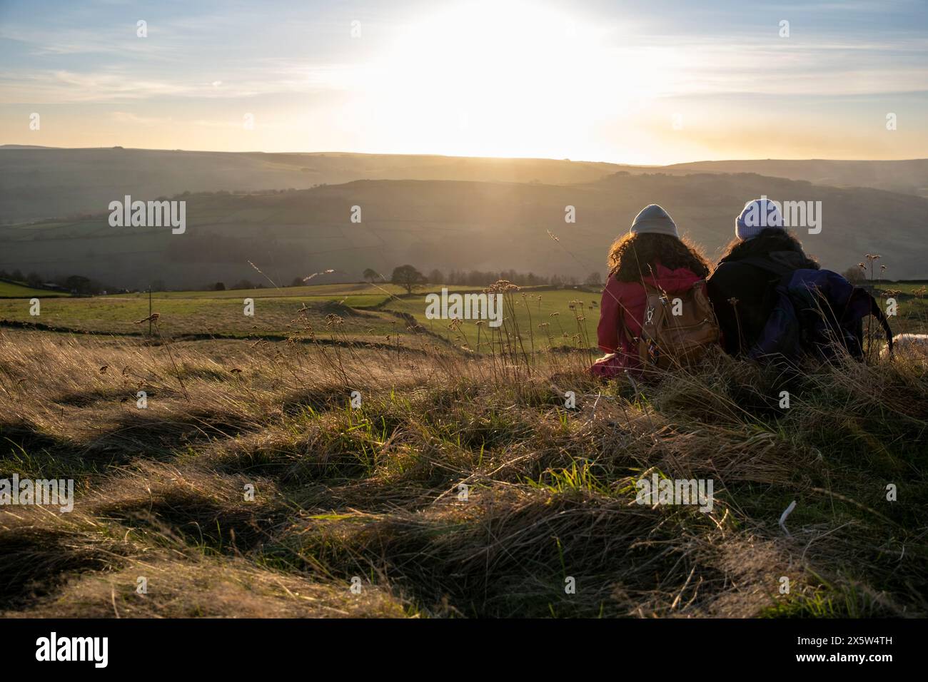 Vue arrière des randonneuses féminines regardant le coucher du soleil Banque D'Images