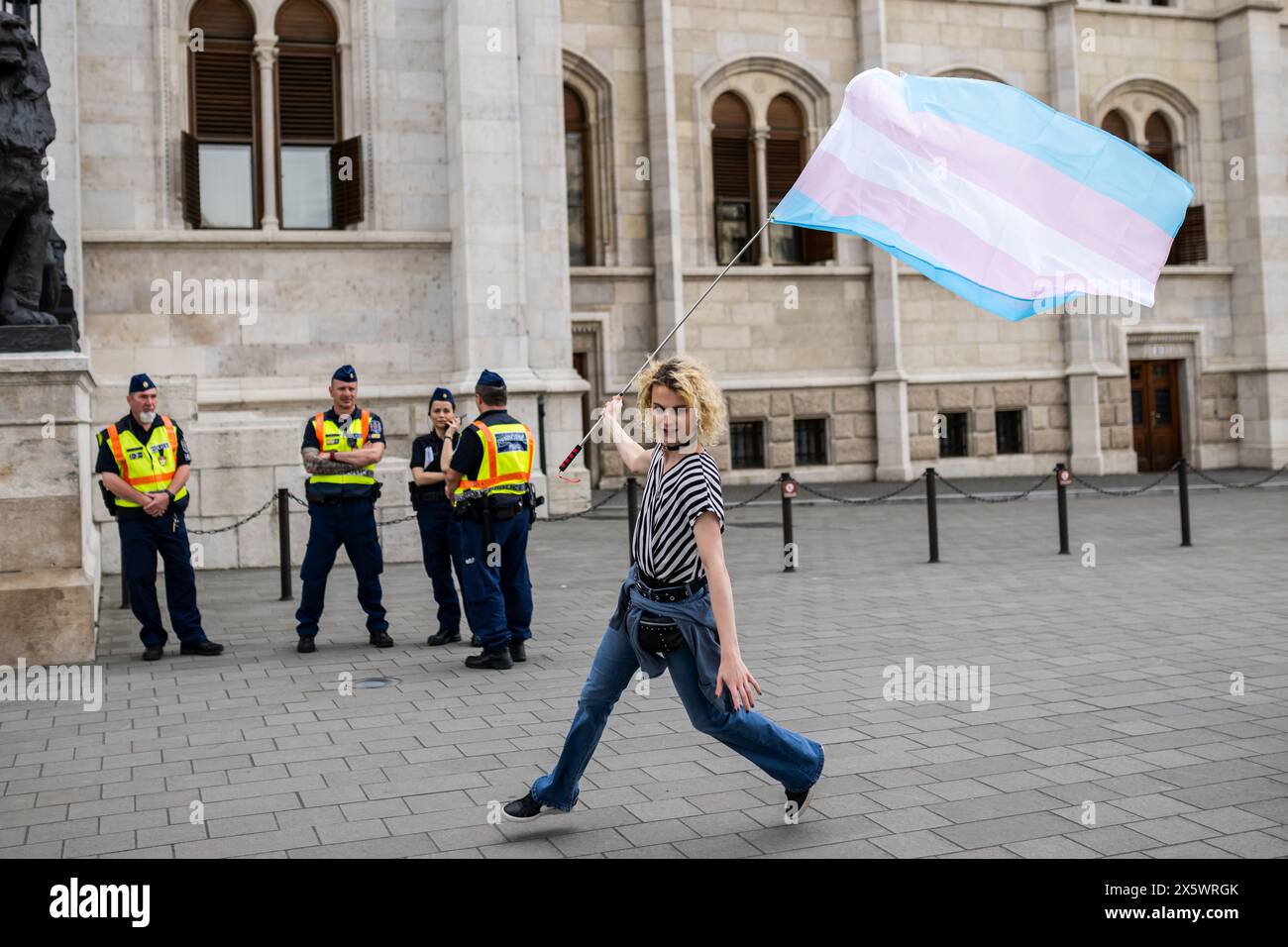 Budapest, Hongrie. 11 mai 2024. Un participant agite un drapeau transgenre devant le Parlement hongrois lors de la marche TRANS Pride. Crédit : Marton Monus/dpa/Alamy Live News Banque D'Images