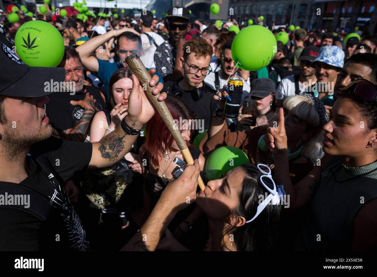 Madrid, Espagne. 11 mai 2024. Un manifestant fume un grand joint, lors d'une manifestation dans les rues de Madrid, commémorant la Marche mondiale de la marijuana. Depuis 1999, chaque premier samedi de mai, la Journée mondiale de la marijuana est célébrée dans le monde entier. Ceux qui ont participé à la marche ont demandé que la marijuana soit légalisée et que la culture et la possession ne soient pas criminalisées. Crédit : SOPA images Limited/Alamy Live News Banque D'Images