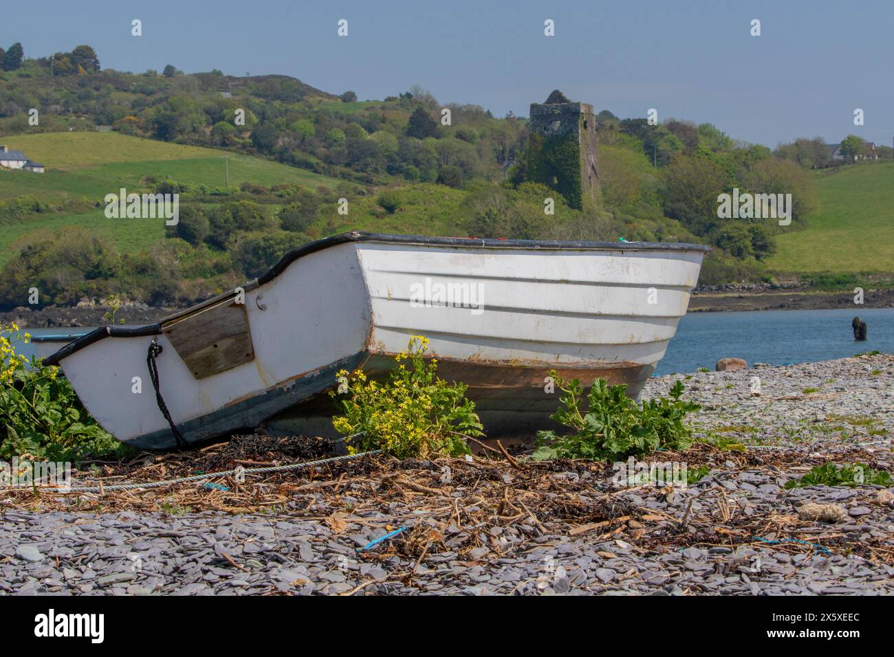 Un bateau en fibre de verre s'est arrêté sur la plage de galets. Banque D'Images