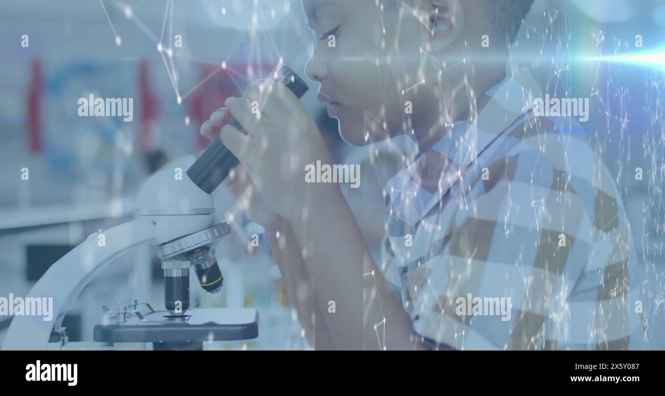 Image de réseaux sur écolier biracial utilisant le microscope en classe de science Banque D'Images