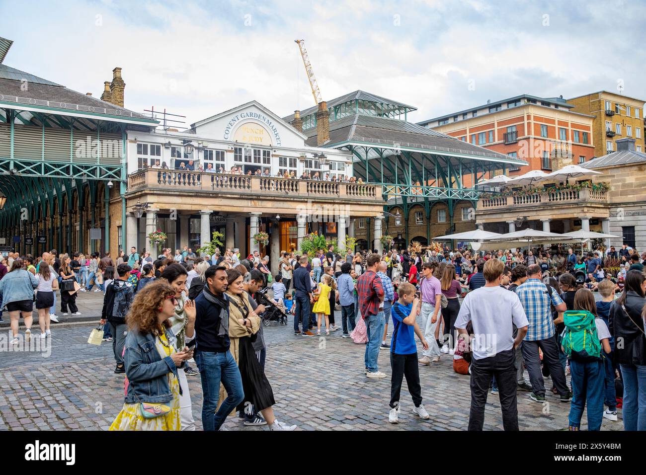 Covent Garden piazza London , les jeunes se mêlent sur la piazza pavée à côté du marché de découverte Garden et Punch & Judy pub, Angleterre, Royaume-Uni, 2023 Banque D'Images