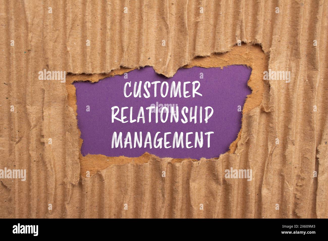 Mots de gestion de la relation client écrits sur du papier cartonné déchiré avec fond violet. Symbo CRM conceptuel de gestion de la relation client Banque D'Images