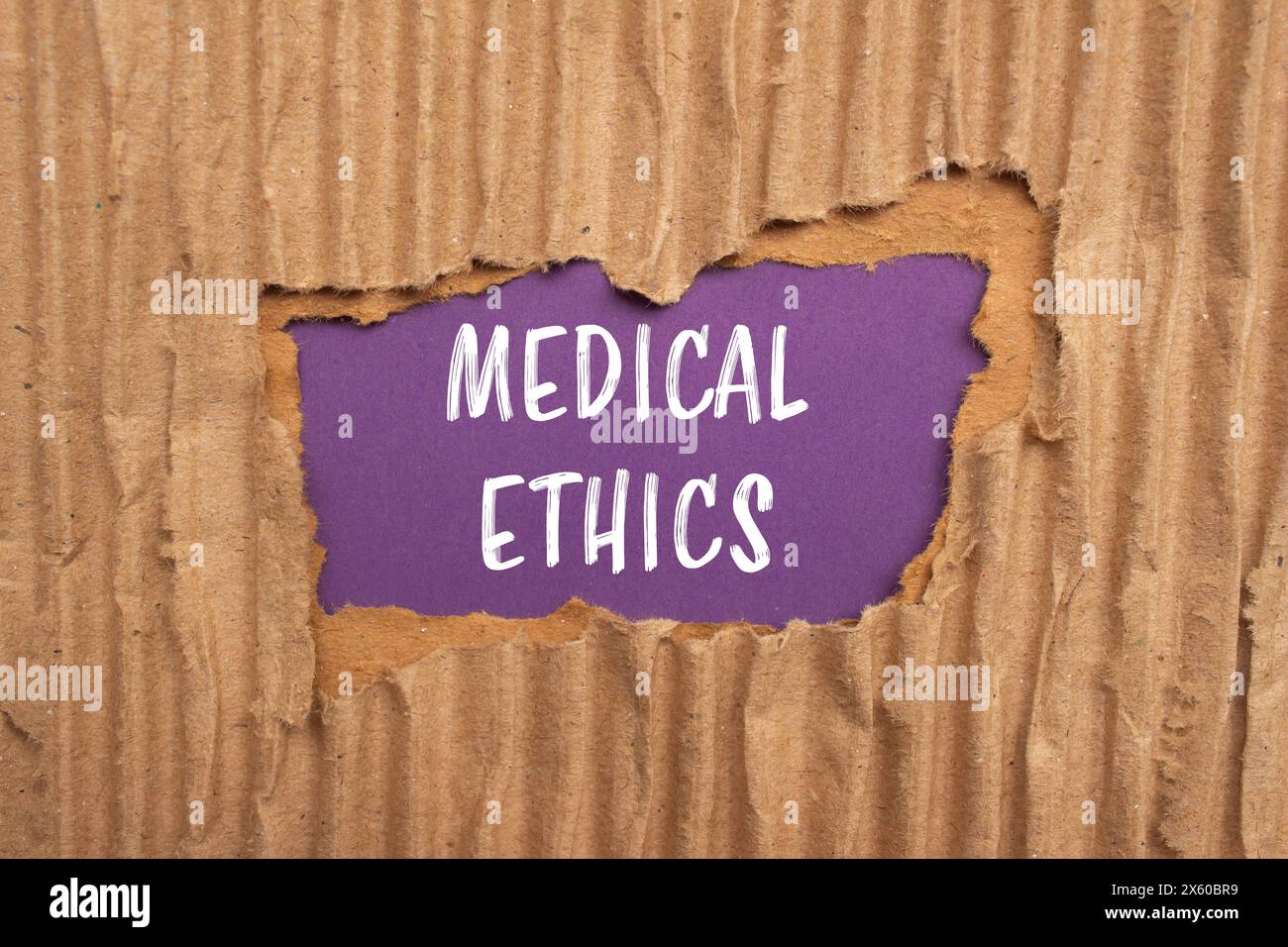 Mots d'éthique médicale écrits sur papier carton déchiré avec fond violet. Symbole conceptuel de l'éthique médicale. Copier l'espace. Banque D'Images