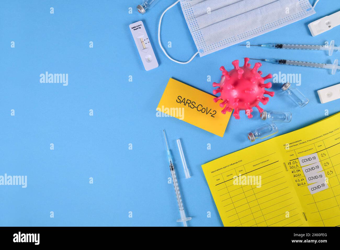 Corona virus flatlay avec passeport de vaccin, sérums, flacons et tests Banque D'Images