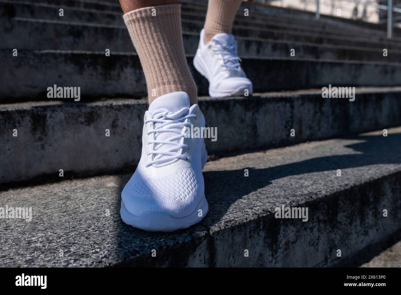 jambes masculines en baskets blanches. Une promenade à travers la ville. Fitness en plein air Banque D'Images