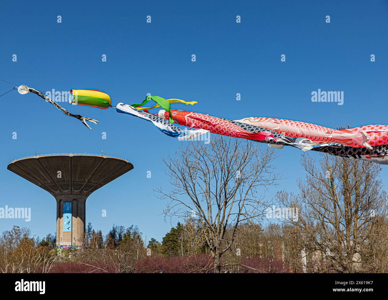 Les chaussettes Koinobori ont volé au Roihuvuori Hanami Festival. En arrière-plan, le château d'eau Roihuvuori. Banque D'Images