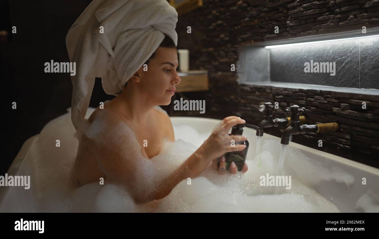 Femme détendue profitant d'un bain moussant de luxe dans une salle de bain moderne à la maison Banque D'Images