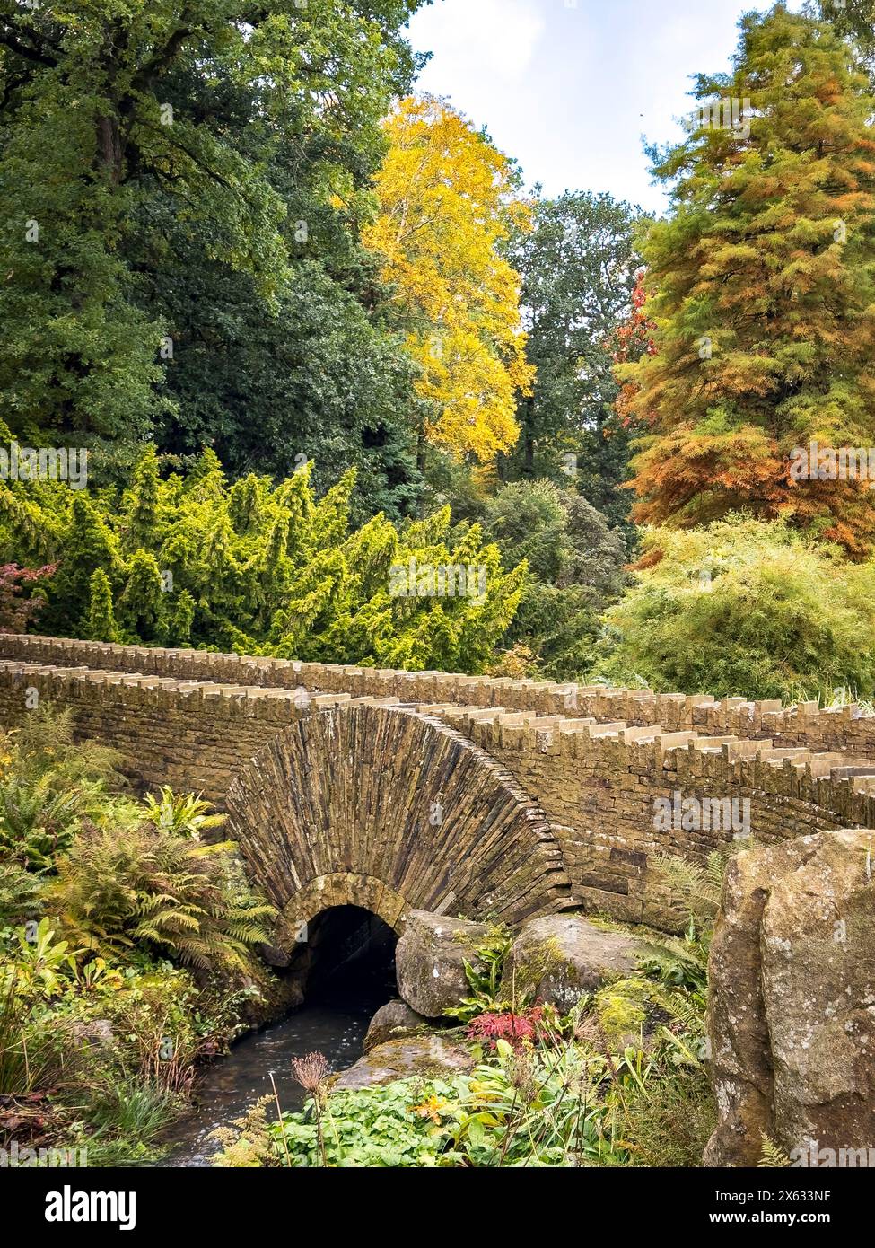 Passerelle en pierre traversant le ruisseau à Harlow Carr Gardens, Harrogate, North Yorkshire, Royaume-Uni Banque D'Images