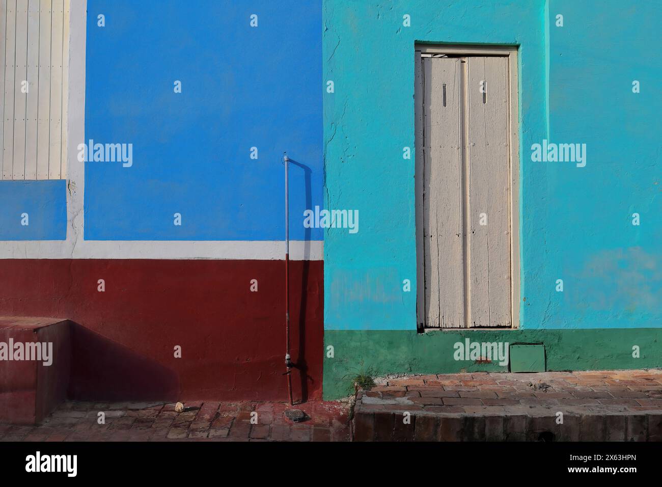 261 mur coloriste de maison coloniale sur le trottoir en briques rouges, avec des portes en bois blanc sur une façade bleu Azur et électrique, marron, verte. Trinidad-Cuba. Banque D'Images