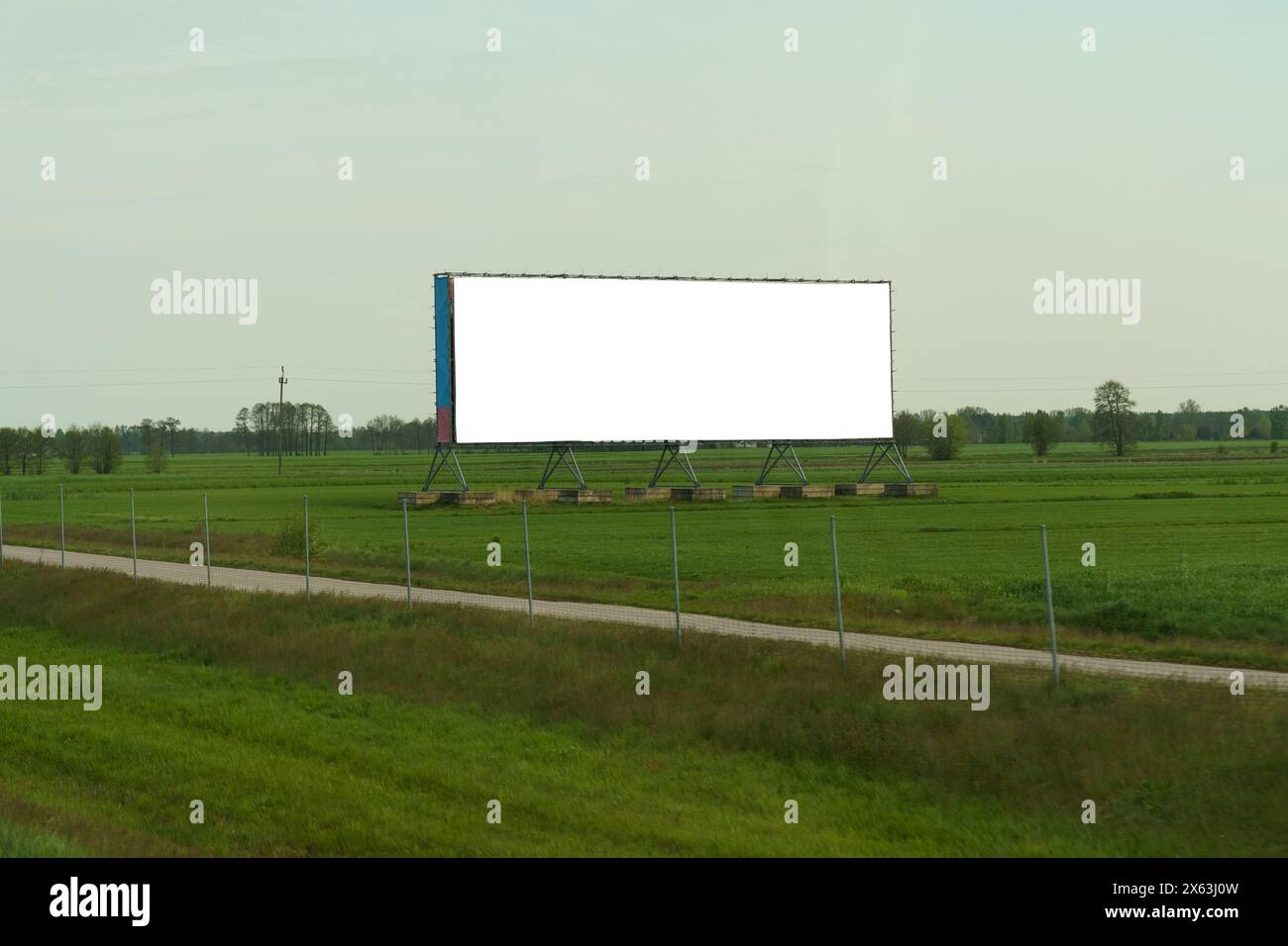 Un panneau d'affichage imposant se distingue le long de la route, captant l'attention des conducteurs de passage avec son message publicitaire audacieux. Banque D'Images