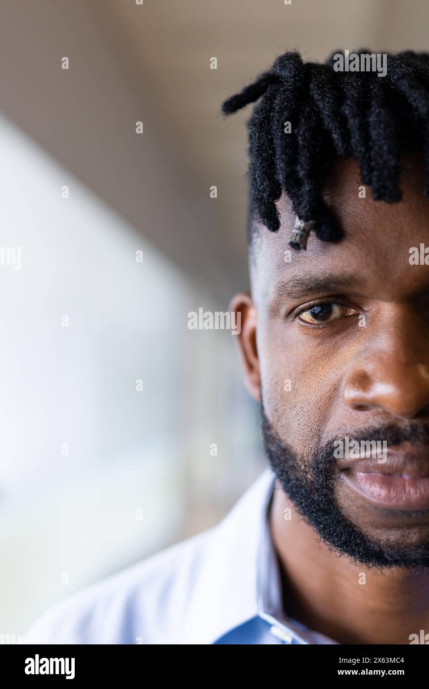 Un homme afro-américain d'âge moyen aux cheveux courts tordus regarde la caméra, l'espace de copie Banque D'Images