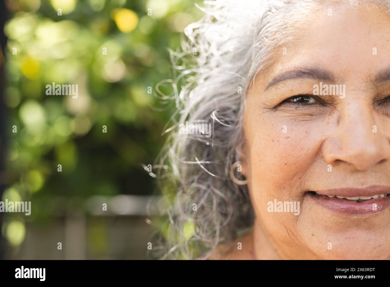 À l'extérieur, femme biraciale senior avec les cheveux gris souriant, espace de copie Banque D'Images