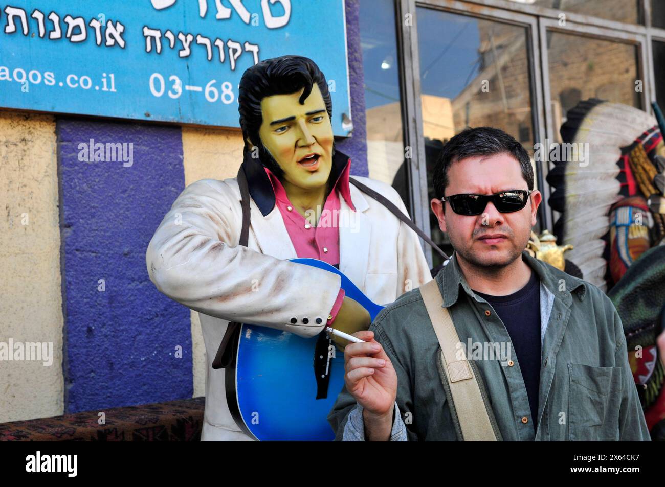 Debout près d'une statue d'Elvis Presley au marché aux puces animé de Jaffa, Israël. Banque D'Images