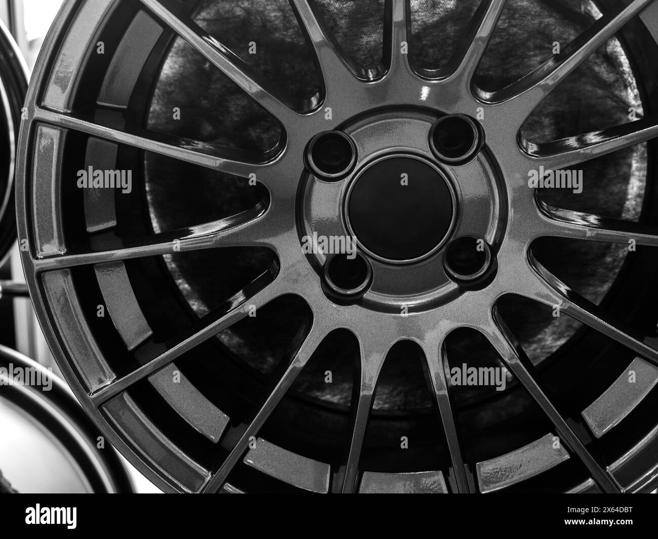 Vue avant de la jante de roues en alliage d'acier sur l'étagère en métal dans le fond de magasin de pneus. Photographie en noir et blanc de roue mag chromée haute performance auto PA Banque D'Images
