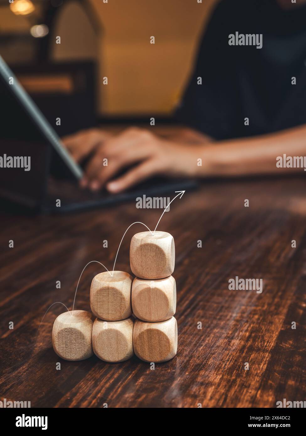 Flèche sautant sur les bâtons en bois graphique à barres étapes sur le bureau tandis que l'homme d'affaires travaillant avec un ordinateur portable, style vertical. Croissance du marché des affaires, effort, Banque D'Images