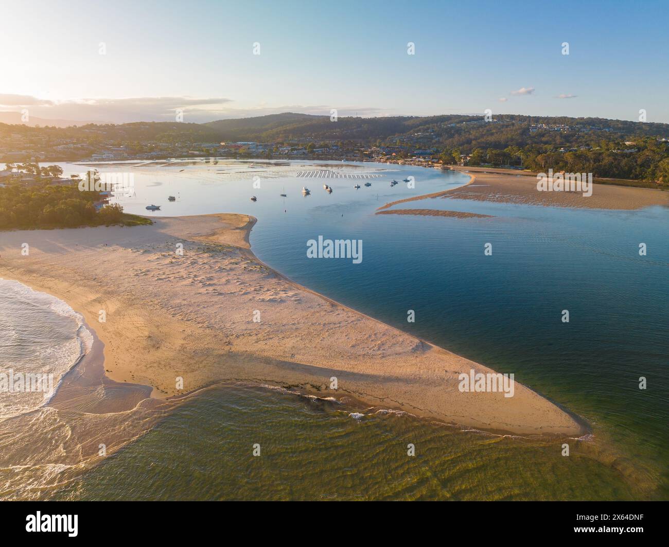 Vue aérienne du coucher de soleil sur une côte avec une longue barre de sable saillante à Merimbula en Nouvelle-Galles du Sud, Australie Banque D'Images