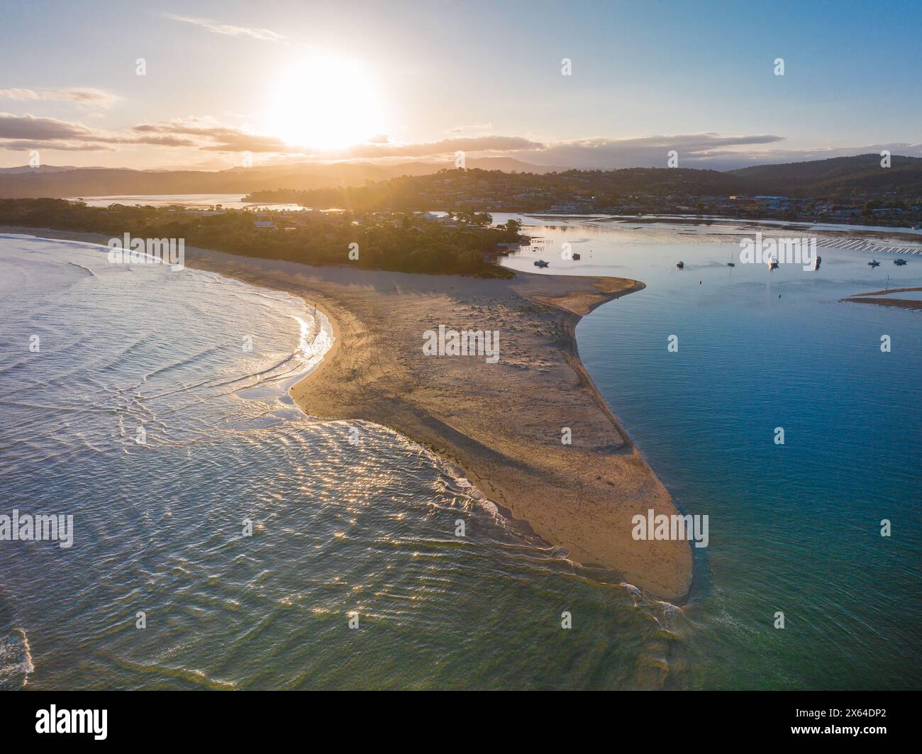 Vue aérienne du coucher de soleil sur une côte avec une longue barre de sable saillante à Merimbula en Nouvelle-Galles du Sud, Australie Banque D'Images