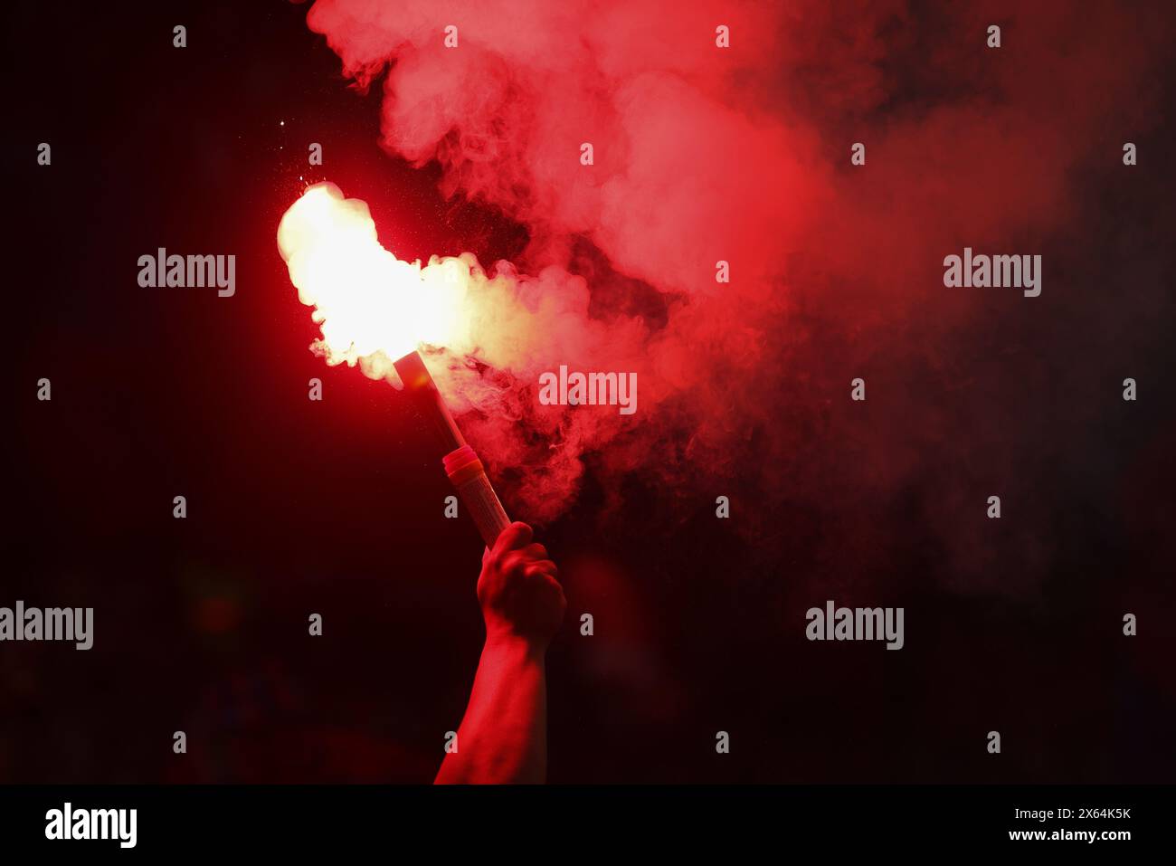 Détails avec les mains d'un homme tenant une torche à l'intérieur pendant un match de football (soccer). Banque D'Images