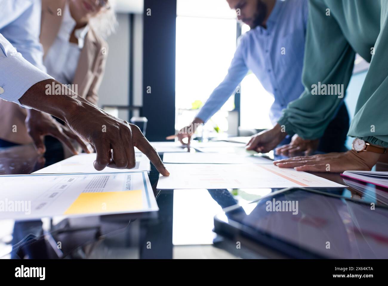 Équipe diversifiée discutant des documents d'affaires au bureau Banque D'Images