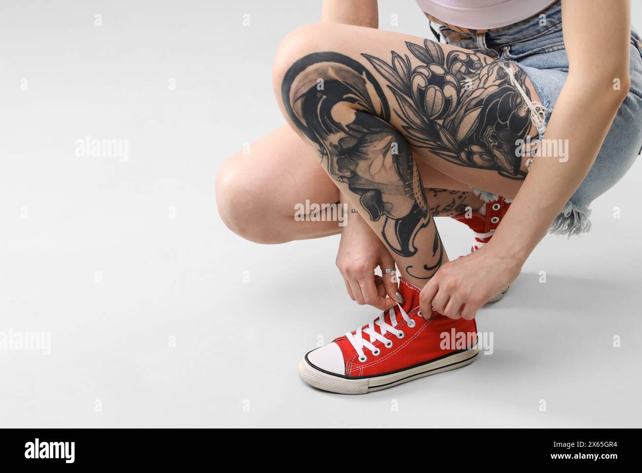 Femme avec des tatouages cool sur fond clair, gros plan. Espace pour le texte Banque D'Images