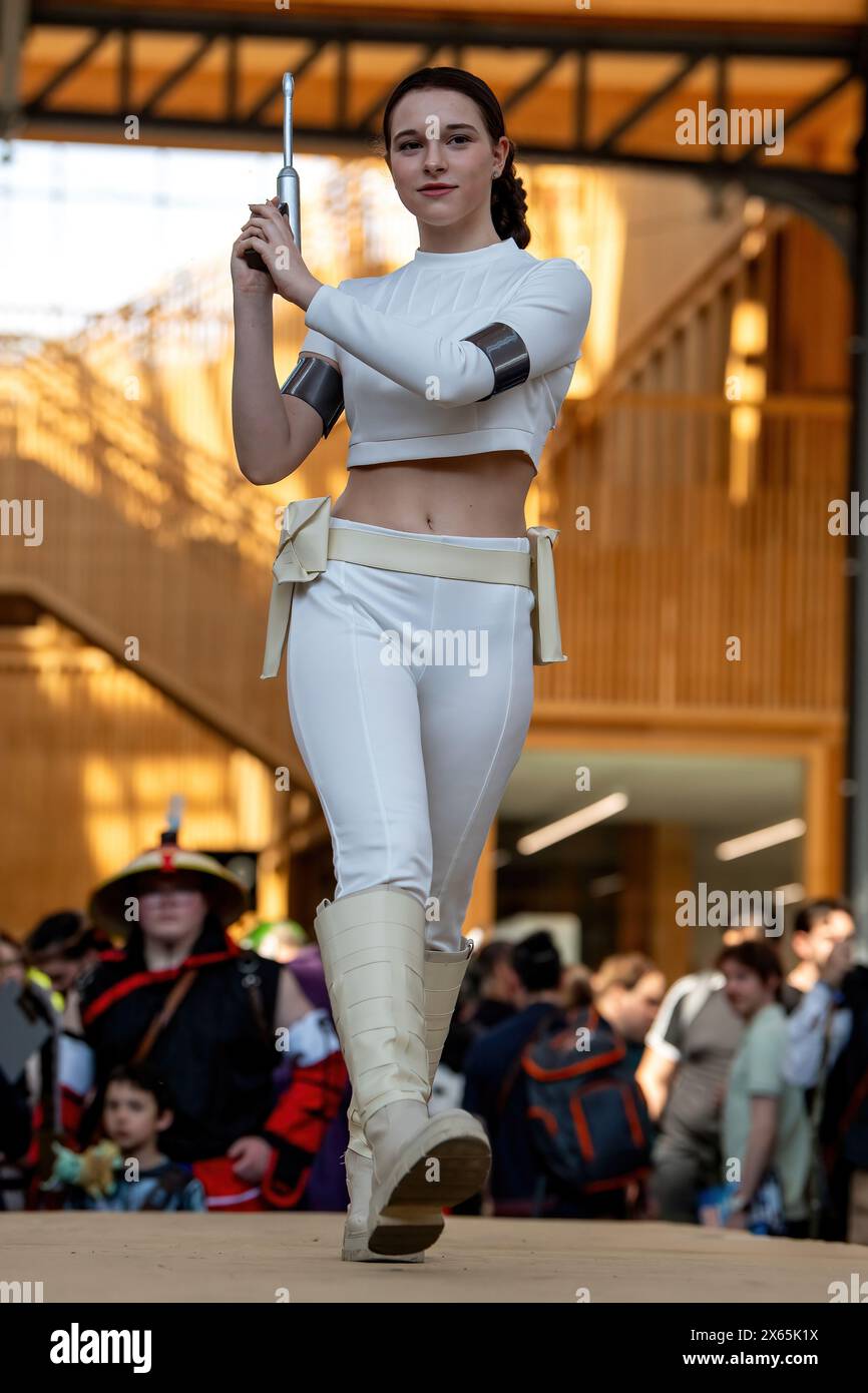 Un Cosplayer habillé en Padmé de Star Wars : Episode II - attaque des clones sur la piste au Comic Con Brussels 2024. Les passionnés de cosplay et les fans de fantasy et de science-fiction ont eu droit à un spectacle spectaculaire de talent et de nostalgie au Comic Con Brussels 2024. L'événement a accueilli des acteurs estimés de franchises bien-aimées, dont Dominic Monaghan, Billy Boyd et Andy Serkis de Lord of the Rings, Deep Roy et Noah Hathaway de The Never Ending Story, et Edward Furlong de Terminator 2. Au milieu de l'excitation, les participants ont montré leur créativité à travers des costumes élaborés, hom payant Banque D'Images