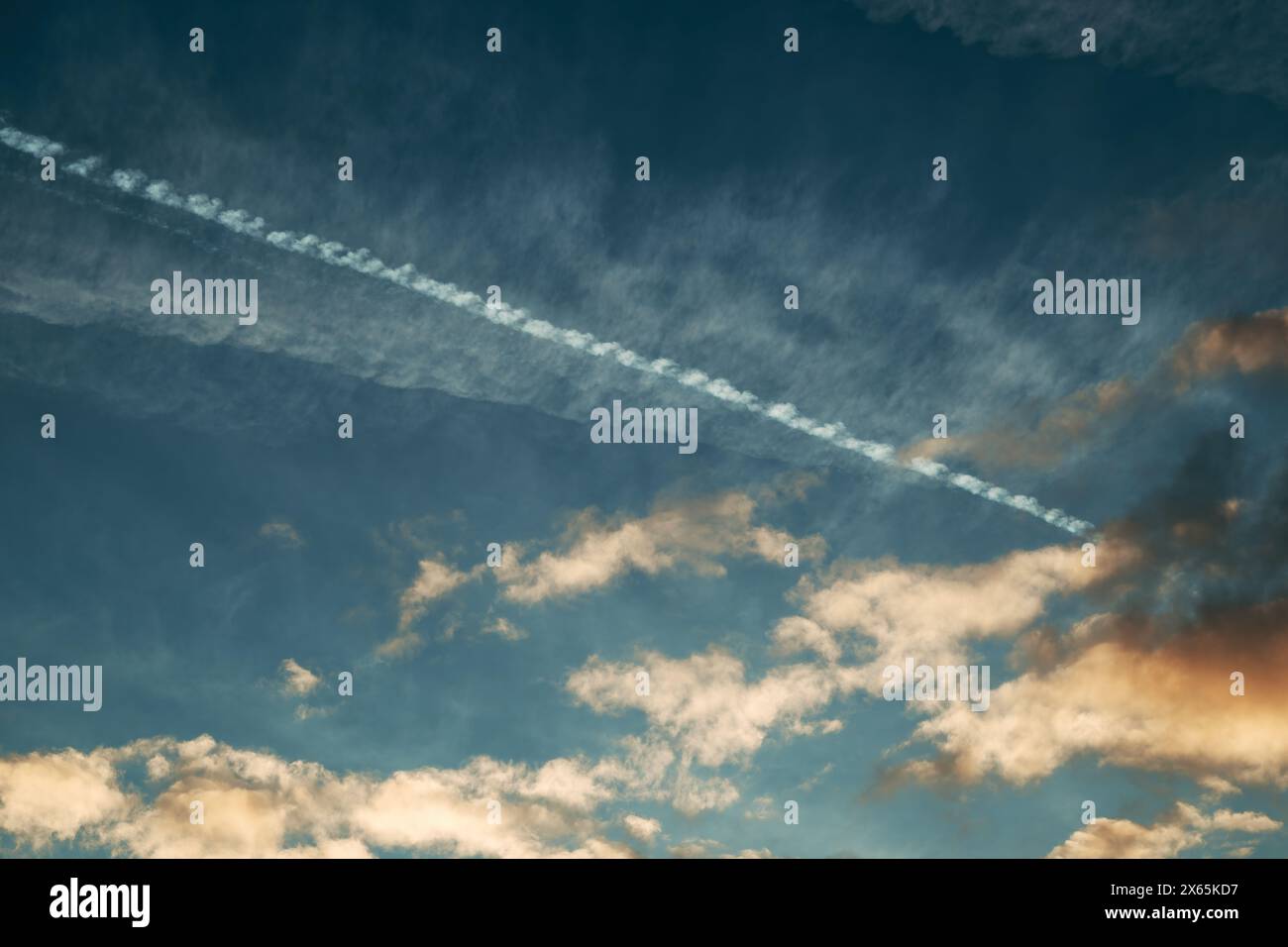 Traînée de contrôle ou de condensation sur le ciel du coucher du soleil, vue à angle bas Banque D'Images