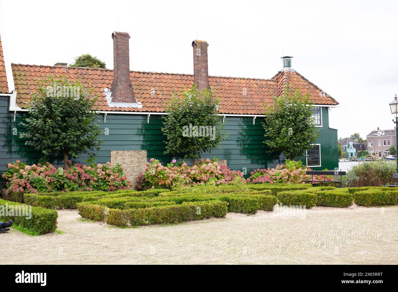 Maison en bois vert à Zaanse Schans avec buissons de buis et fleurs Banque D'Images