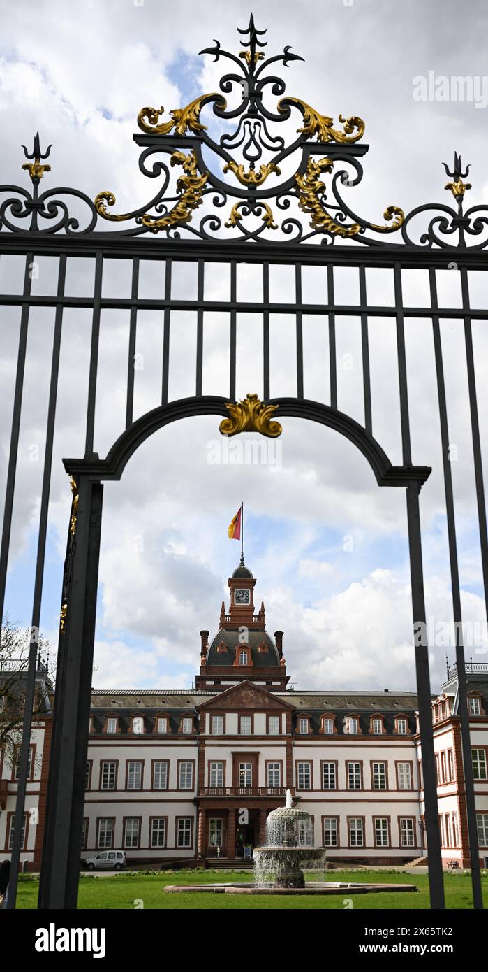 Hanau, Allemagne. 10 avril 2024. Une porte offre une vue sur le Palais Philippsruhe dans le quartier de Kesselstadt. Le palais baroque a été construit entre 1700 et 1725 par le comte Phlipp Reinhard von Hanau. Crédit : Arne Dedert/dpa/Alamy Live News Banque D'Images