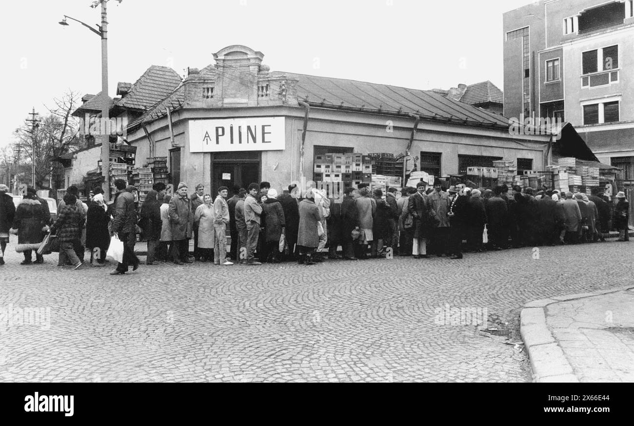 Bucarest, Roumanie, janvier 1990. Moins d'un mois après la révolution anticommuniste de décembre 1989, les gens restent dans de longues files d'attente pour se procurer des provisions de base. Le système économique socialiste centralisé a créé la pénurie et la faim. Ici, une ligne devant un magasin de pain. Banque D'Images