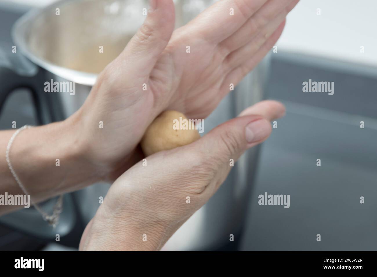 tenir une pomme de terre au-dessus d'une casserole, se préparer à cuisiner dans une cuisine avec un éclairage doux et naturel Banque D'Images