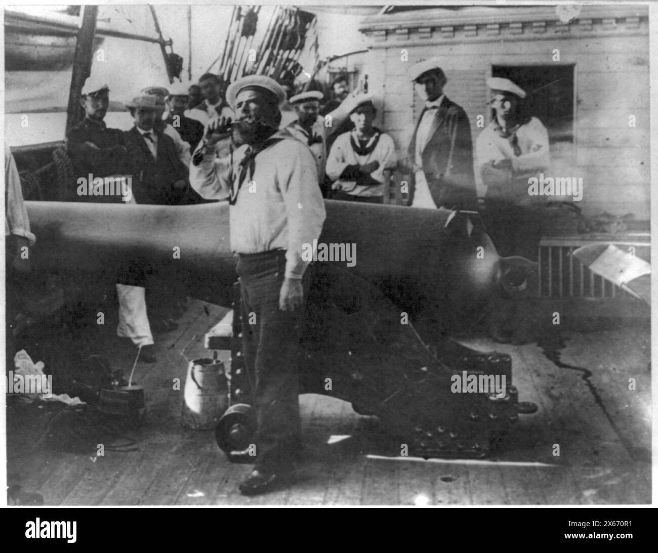 Tuyauterie en bateau devant un grand canon sur le pont du navire de guerre de la marine américaine ; d'autres marins debout en arrière-plan, photographies de la guerre de Sécession 1861-1865 Banque D'Images