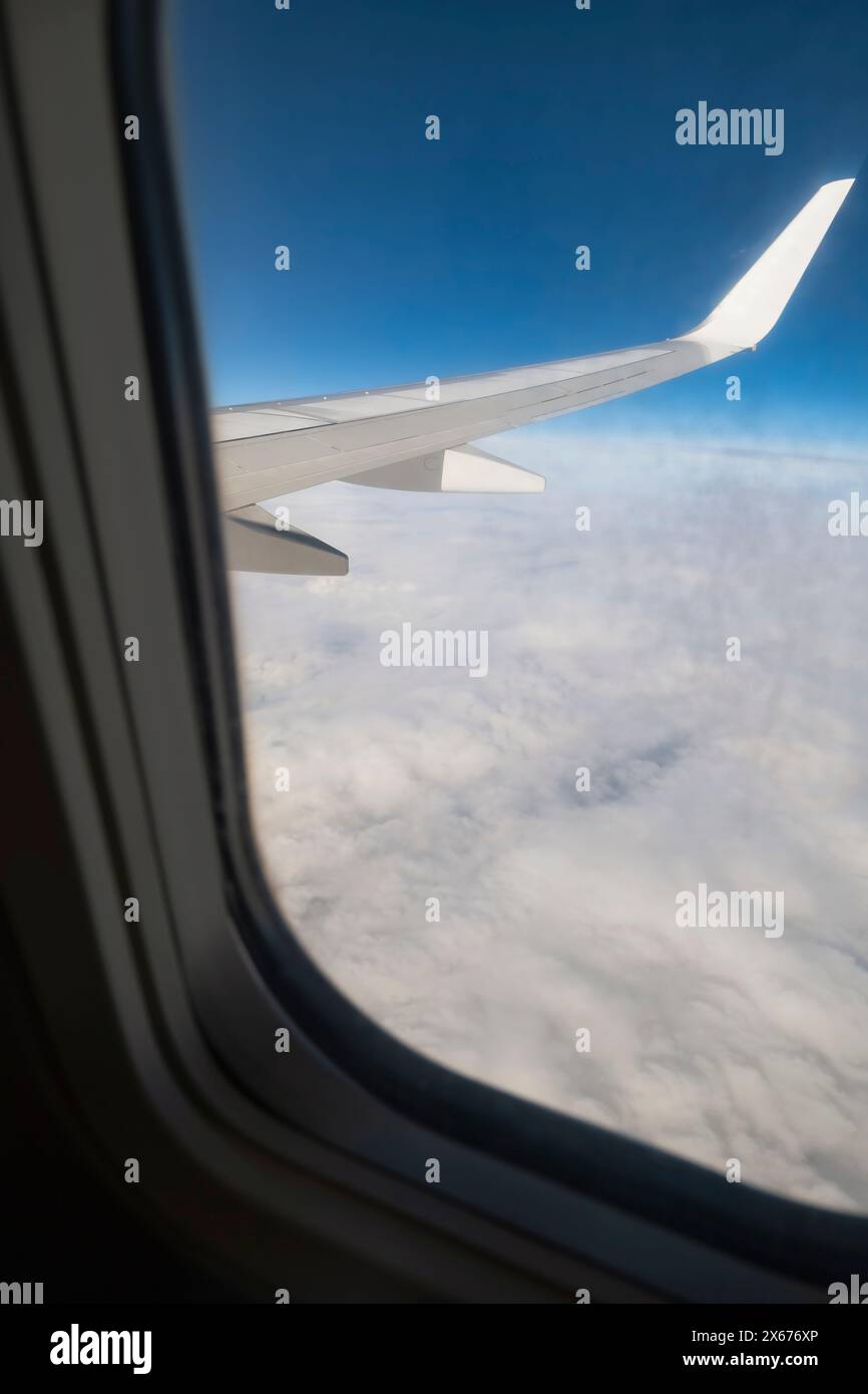 Vue depuis une fenêtre d'avion, aile d'avion et nuages blancs Banque D'Images