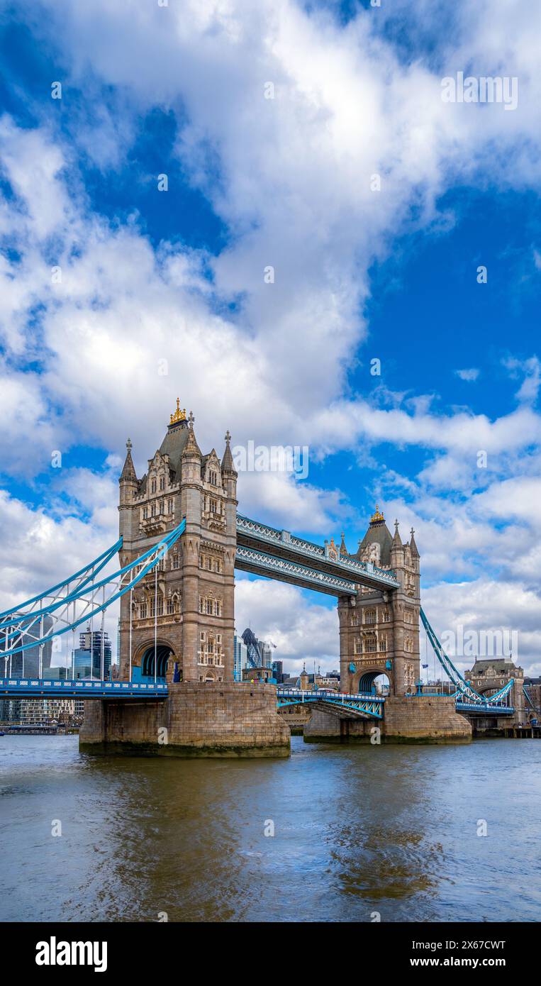 Vue diagonale du Tower Bridge de Londres avec son reflet dans la Tamise sous un ciel bleu avec des nuages blancs. Royaume-Uni. Banque D'Images