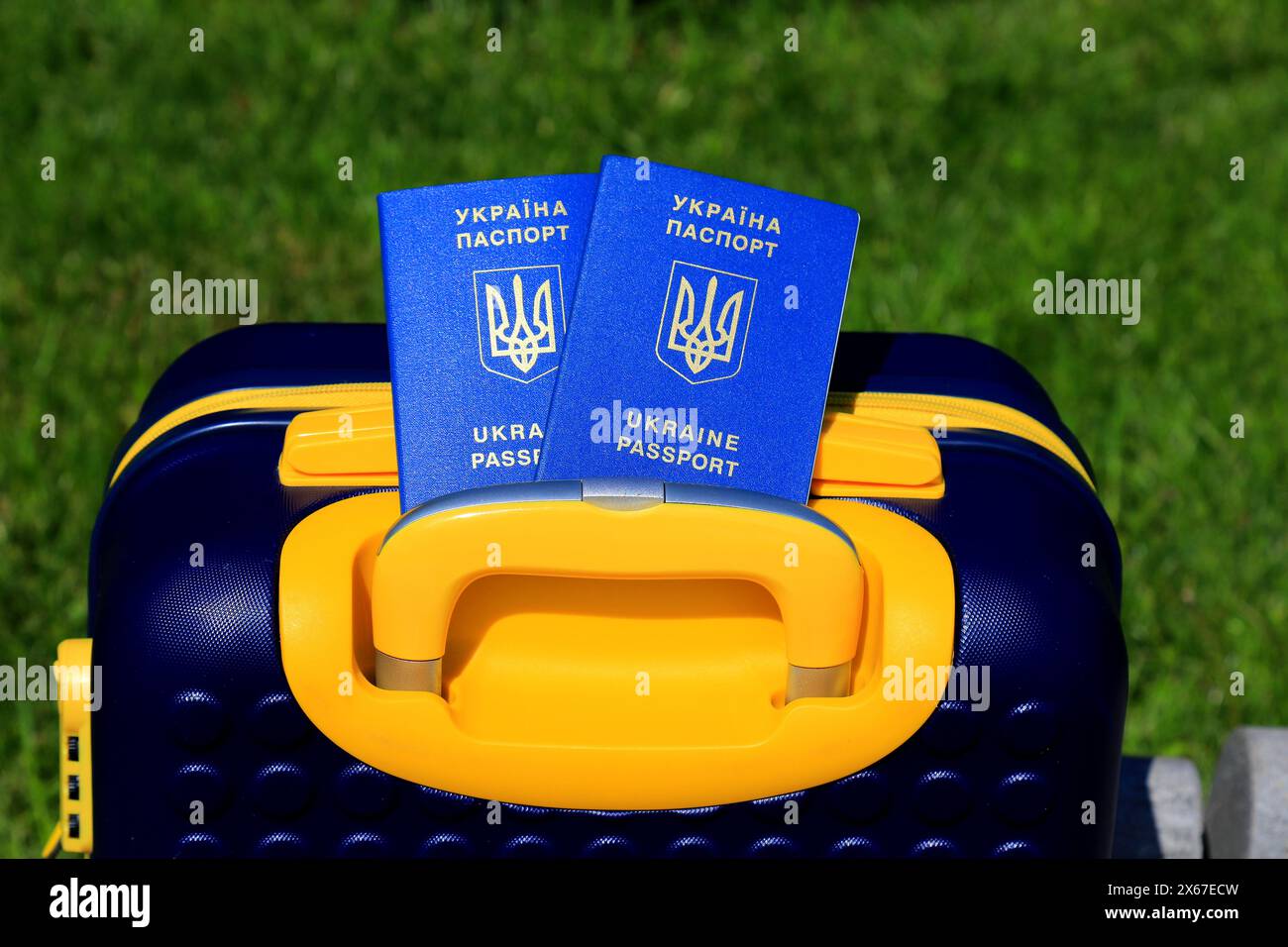 2 passeports Ukraine citoyens avec inscription en ukrainien - passeport de l'Ukraine reposent sur la valise jaune bleu en couleur du drapeau ukrainien. Voyage, refuge Banque D'Images