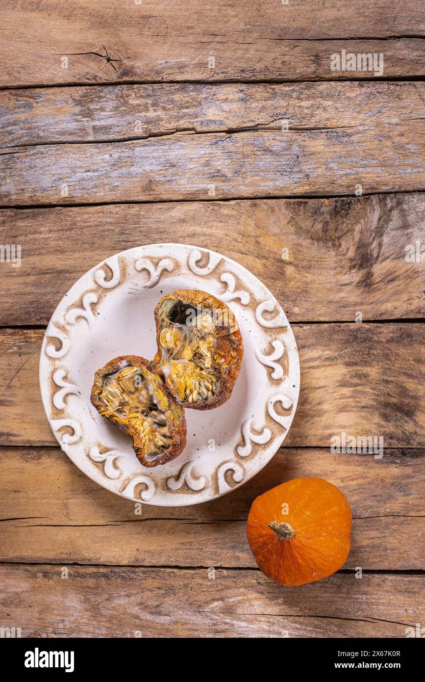 Nature morte automnale, citrouille gâtée sur une assiette Banque D'Images