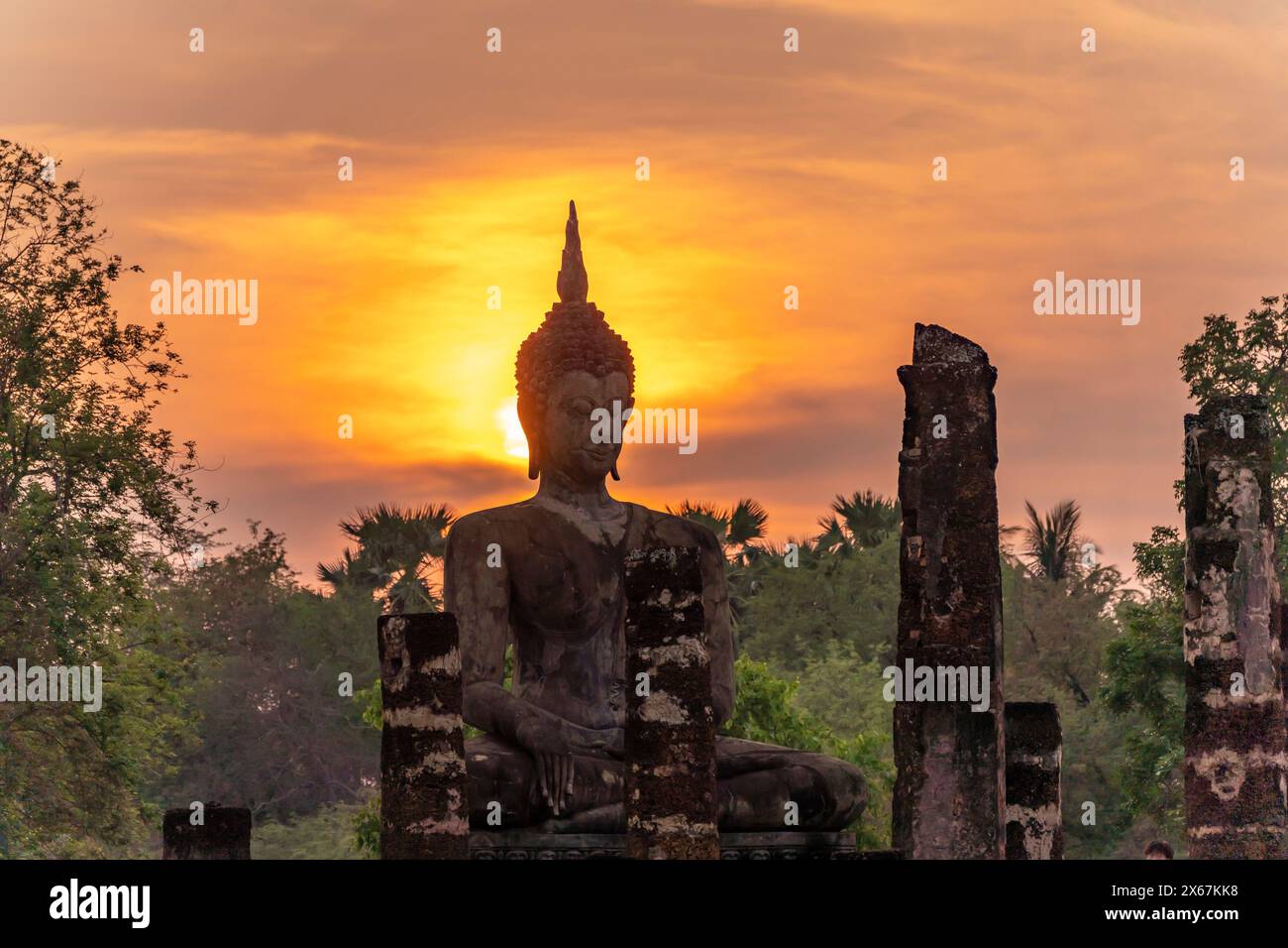 Coucher de soleil à une statue de Bouddha du temple Wat Mahathat, patrimoine mondial de l'UNESCO Parc historique de Sukhothai, Thaïlande, Asie Banque D'Images