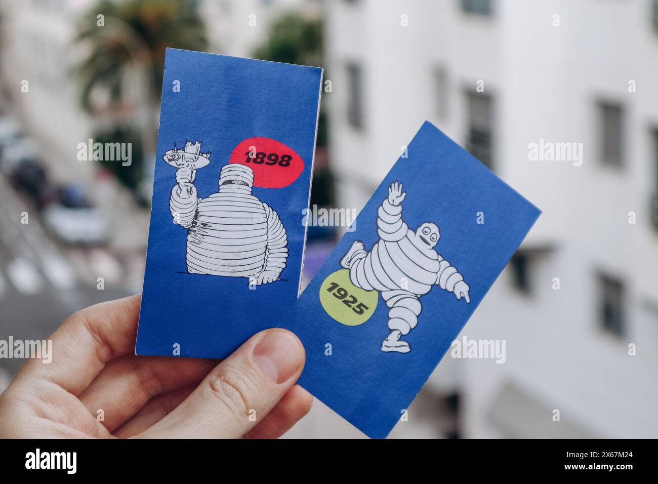 Nice, France - 27.01.2024 : la main d'un homme tient des photos vintage de Bibendum, la mascotte de la marque Michelin. Banque D'Images