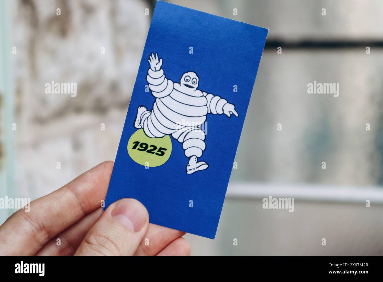 Nice, France - 27.01.2024 : la main d'un homme tient des photos vintage de Bibendum, la mascotte de la marque Michelin. Banque D'Images