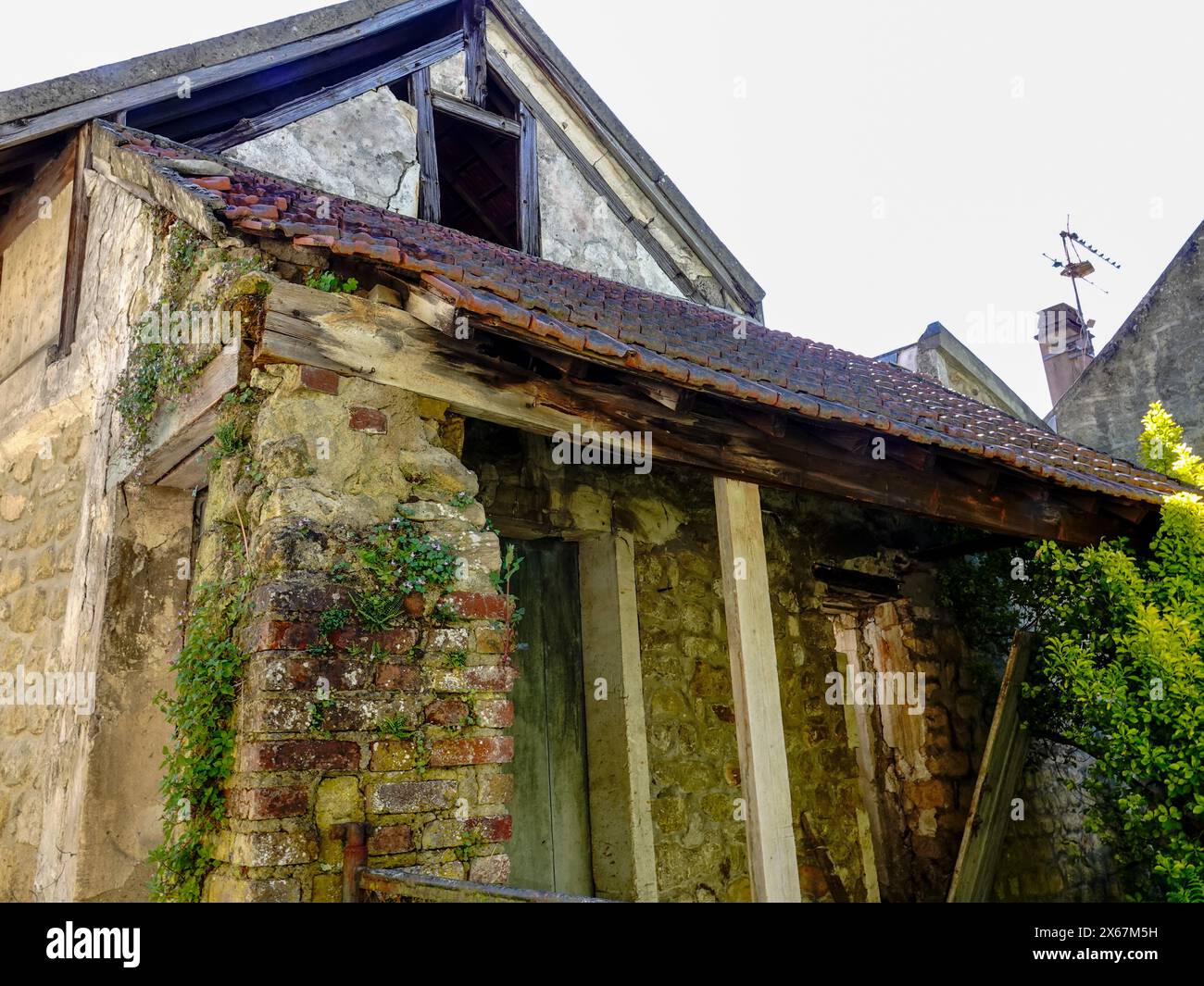 Charmante maison ancienne en brique, pierre et tuile, bâtiment en besoin de réparation, Auvers-sur-Oise, France. Banque D'Images