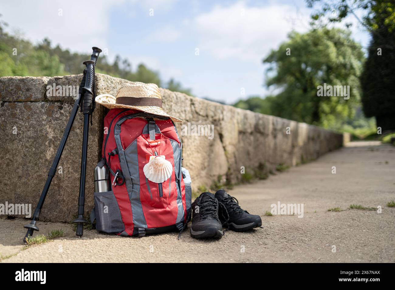 Sac à dos et autre équipement d'un pèlerin à Saint-Jacques-de-Compostelle appuyé contre un mur de pierre. Camino de Santiago concept. Copier l'espace Banque D'Images