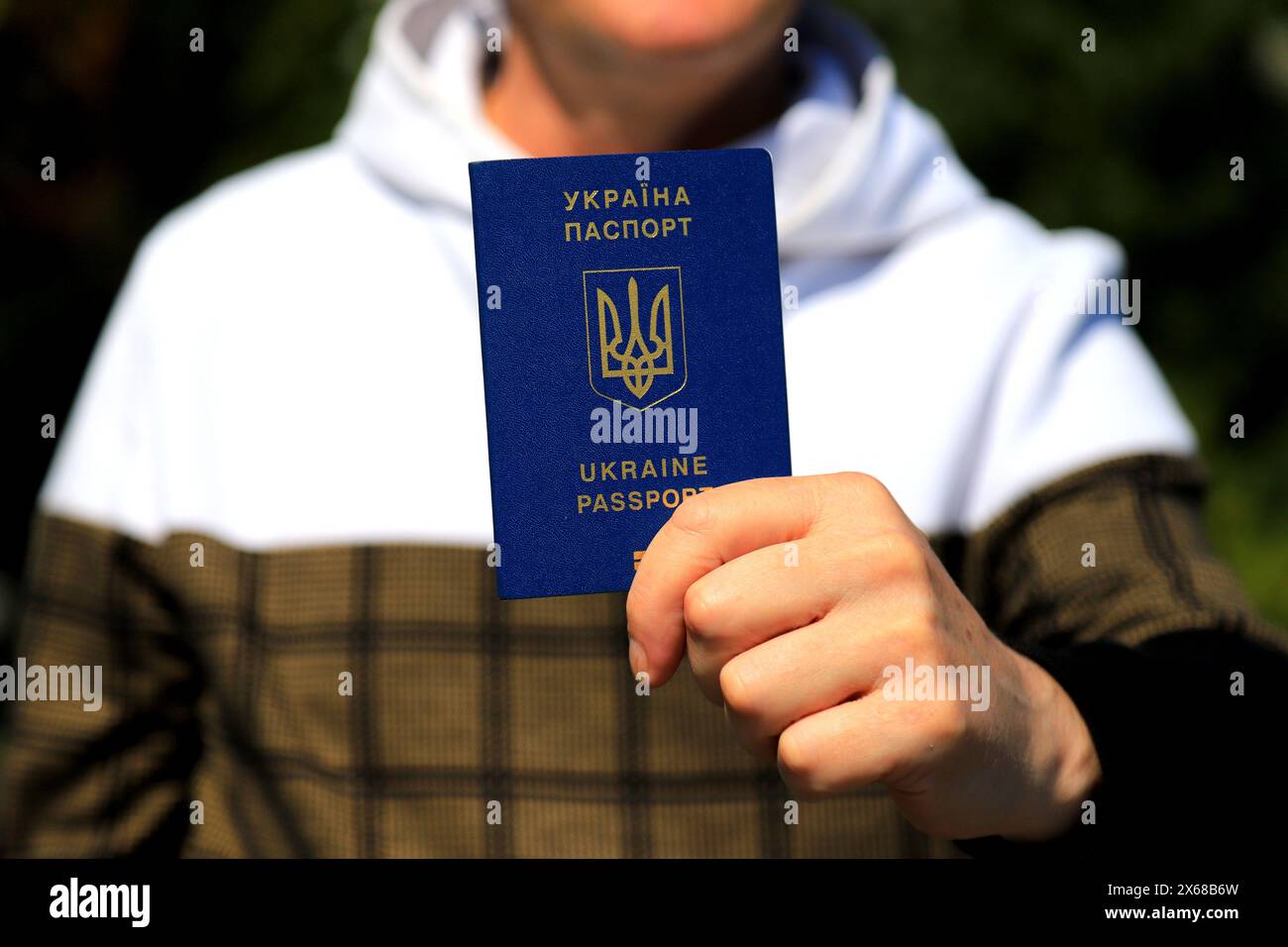 Un homme tient dans ses mains un passeport ukrainien avec une inscription en ukrainien - passeport de l'Ukraine. Concept de voyage, réfugié, touriste, émigrant, mobi Banque D'Images